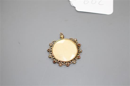 A Middle Eastern? yellow metal, white opal an red paste? set glazed circular pendant, overall diameter 37mm, gross 5.7 grams.